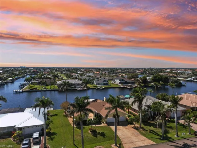 Aerial view at dusk featuring a water view and a residential view