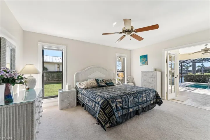 Carpeted bedroom featuring access to outside, a sunroom, and ceiling fan