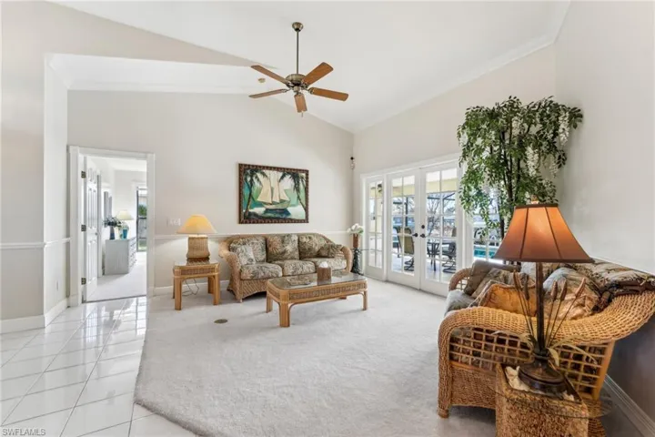Living room featuring ornamental molding, french doors, light tile patterned floors, and baseboards