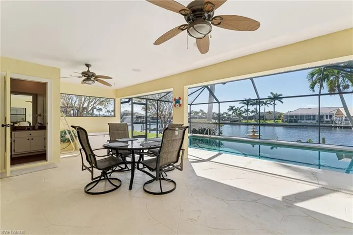 Sunroom / solarium with a pool, a water view, and ceiling fan