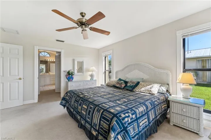 Bedroom with light carpet, baseboards, visible vents, and a ceiling fan