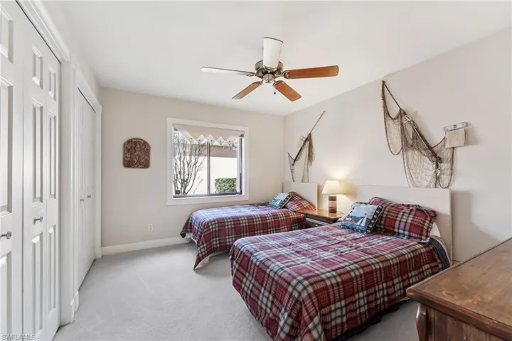 Carpeted bedroom featuring ceiling fan and baseboards