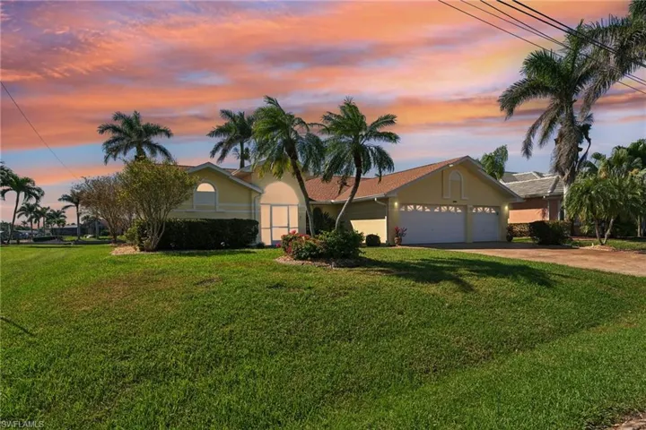 Single story home with a garage, driveway, a front yard, and stucco siding