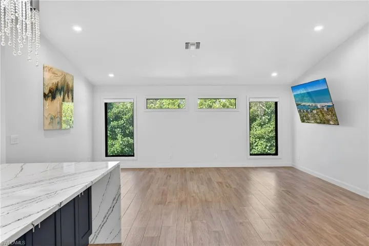 Spacious living area by kitchen with large windows and exceptional lighting.