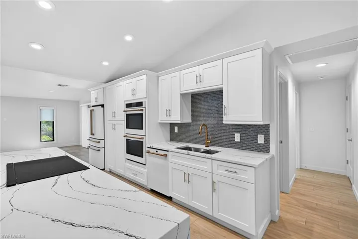 New GE Cafe appliances, light stone countertops, custom cabinets, vaulted ceilings, luxury lighting