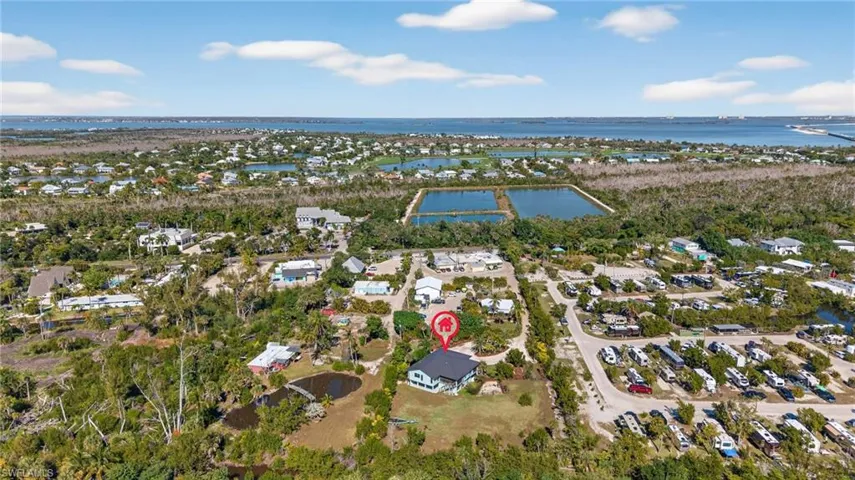 Aerial view of property and surrounding area featuring nearby suburban area and a nearby body of water