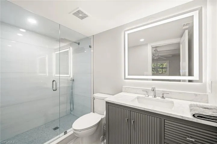 Full bath featuring a stall shower, vanity, ceiling fan, and recessed lighting