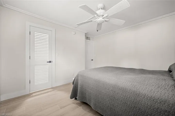 Bedroom featuring wood tiled floors, ornamental molding, and ceiling fan