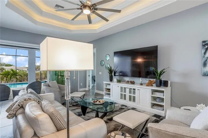 Living area featuring a ceiling fan and ornamental molding