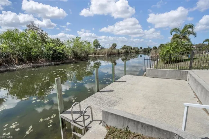 Dock with a water view and view of wooded area