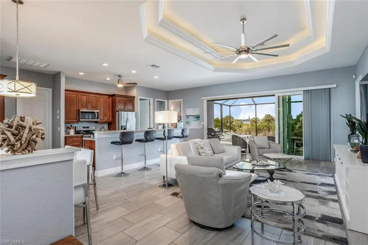 Living room with a ceiling fan, wood tiled floors, a sunroom, and recessed lighting