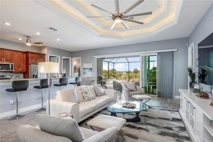 Living area featuring a sunroom, a ceiling fan, light wood-style flooring, and recessed lighting