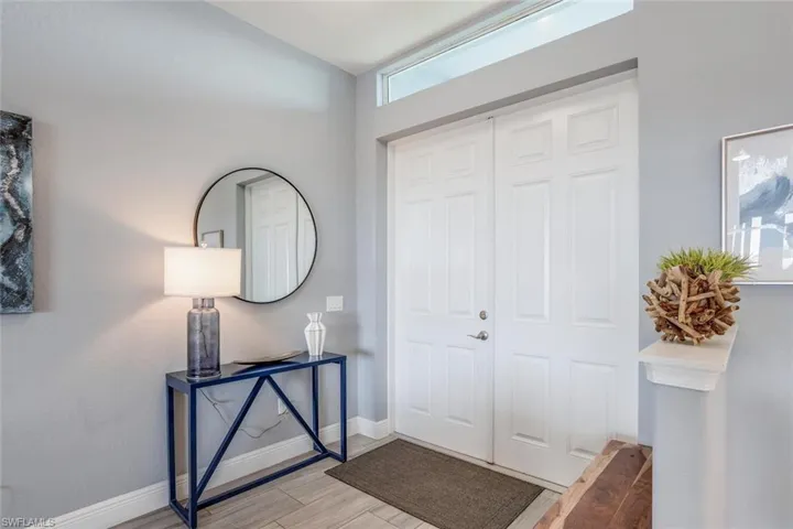 Foyer entrance with baseboards and wood finish floors