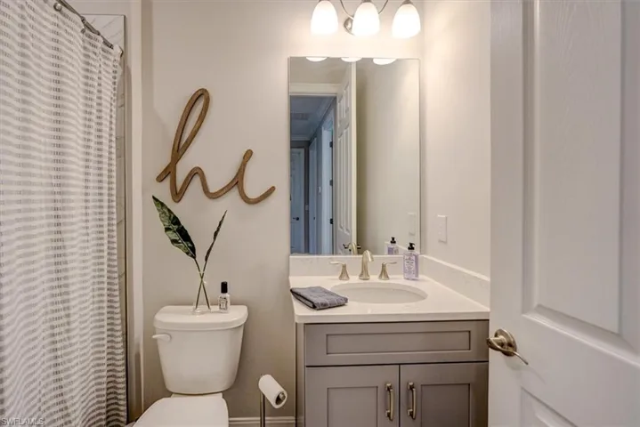 Bathroom featuring vanity, a shower with curtain, and toilet