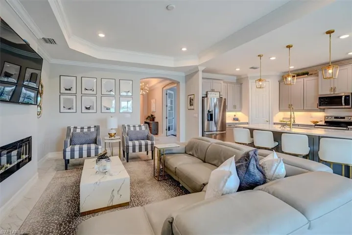 Living room featuring ornamental molding, recessed lighting, visible vents, arched walkways, and marble finish floor