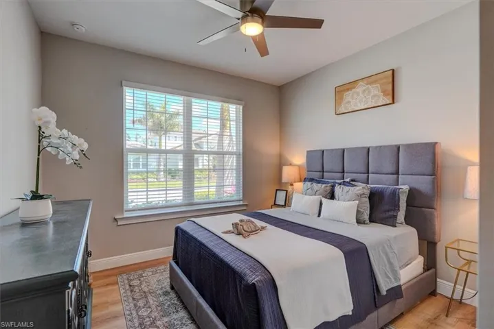 Bedroom with light wood-style flooring, baseboards, and ceiling fan