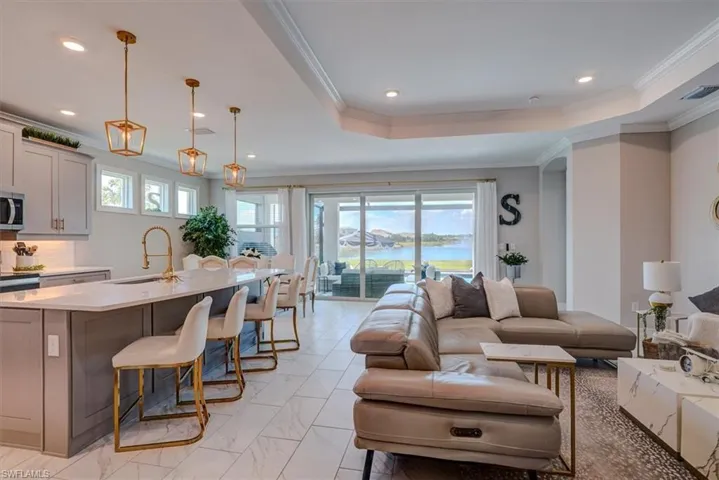 Living area featuring visible vents, a water view, crown molding, recessed lighting, and marble finish floor