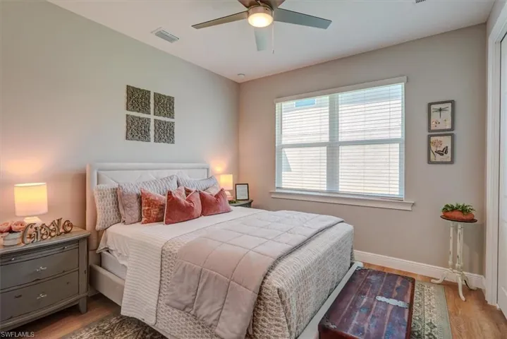 Bedroom featuring visible vents, baseboards, a ceiling fan, and wood finished floors