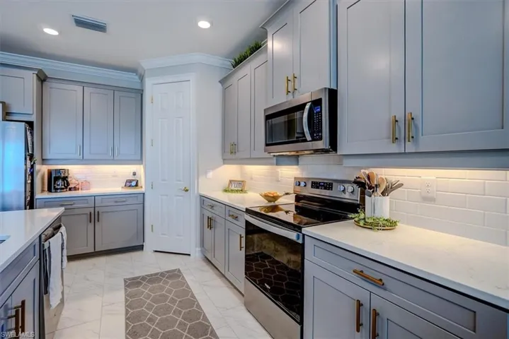 Kitchen with visible vents, gray cabinets, marble finish floor, and stainless steel appliances