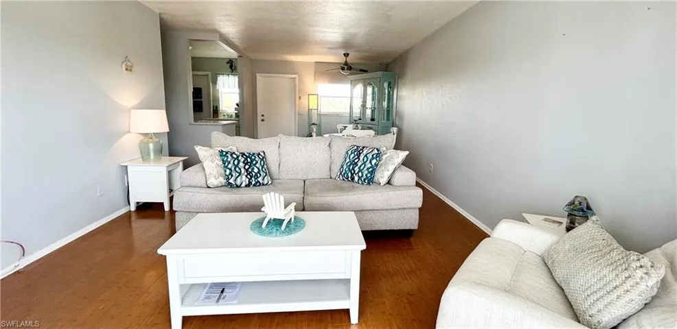 Living area with wood finished floors, ceiling fan, and a textured ceiling