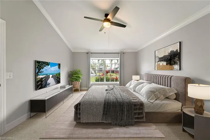 Bedroom featuring crown molding, light colored carpet, and ceiling fan