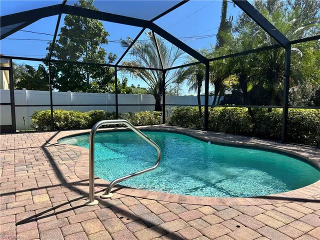 View of swimming pool with a sunroom, a lanai, and a patio