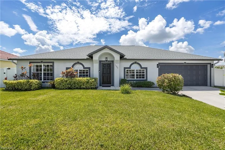 View of front of property with stucco siding, driveway, and a garage