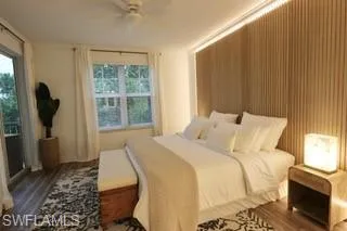 Bedroom with dark hardwood / wood-style floors, multiple windows, and ceiling fan