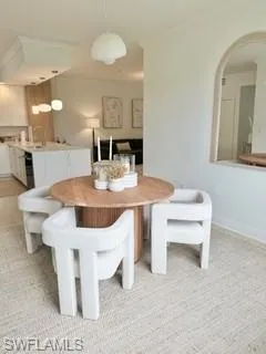 Dining room with light colored carpet and crown molding
