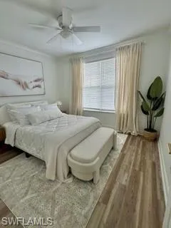 Bedroom with ceiling fan, hardwood / wood-style floors, and crown molding