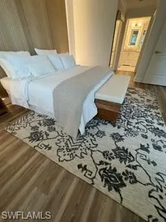 Bedroom featuring ensuite bathroom and dark hardwood / wood-style floors