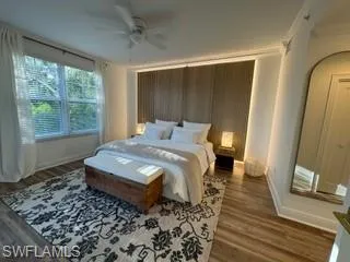 Bedroom with dark hardwood / wood-style flooring, ornamental molding, and ceiling fan