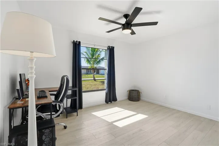 Office space with light wood-style floors and a ceiling fan