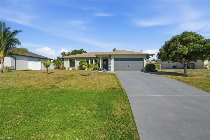 Ranch-style house with concrete driveway, a garage, and stucco siding