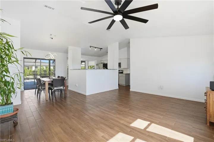 Living area featuring vaulted ceiling, wood finish floors, and ceiling fan