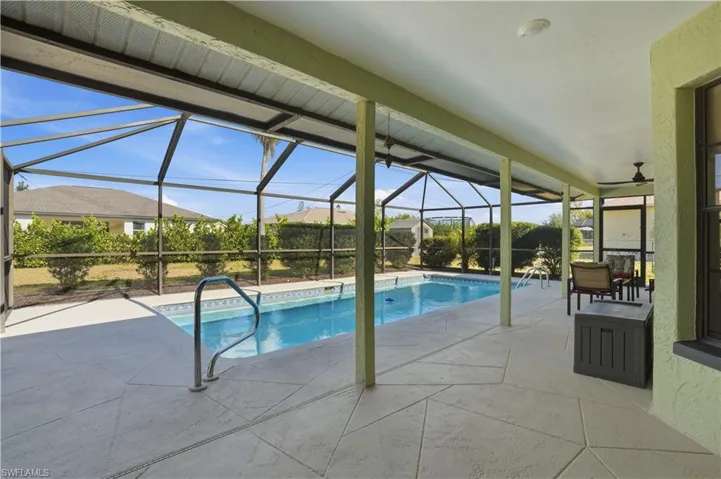 Outdoor pool featuring a patio, a sunroom, and glass enclosure