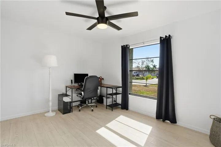 Office with light wood finished floors and ceiling fan