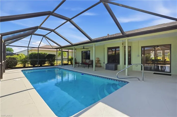 Outdoor pool with a sunroom, a patio area, and a lanai