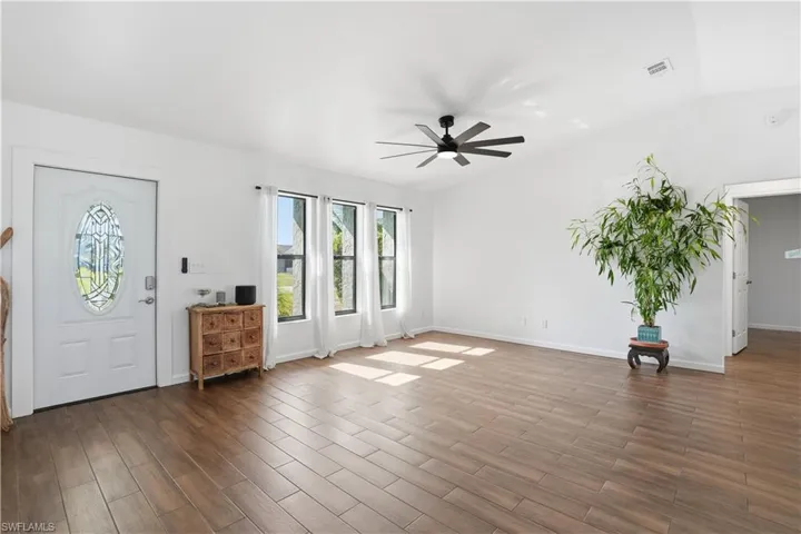 Foyer entrance featuring lofted ceiling, wood tiled floors, and a ceiling fan