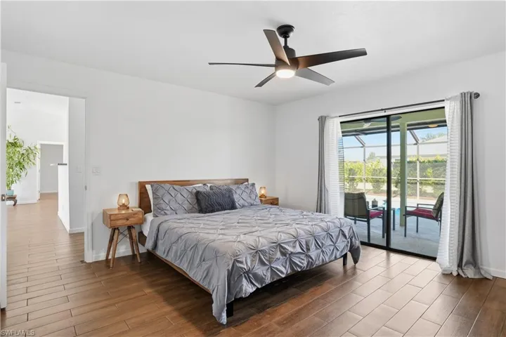 Bedroom featuring wood finished floors, access to outside, and a ceiling fan