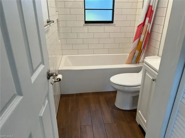 Full bathroom featuring vanity, dark wood-style floors, and shower / bath combo