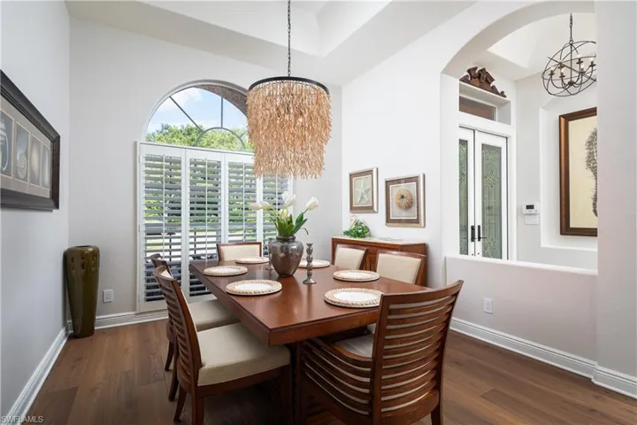 Dining space with a chandelier and dark wood-type flooring
