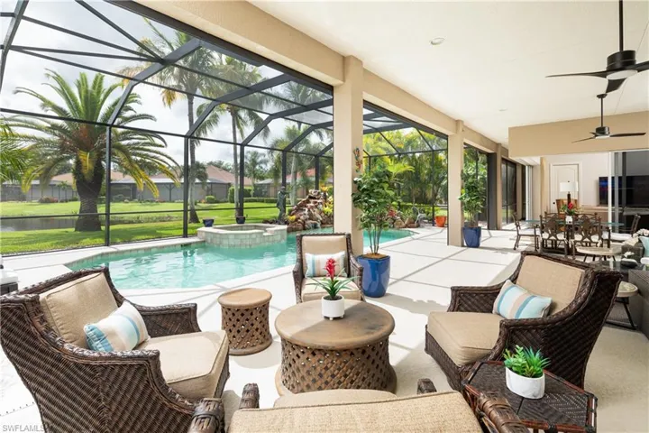 View of pool with a lanai, an in ground hot tub, a patio area, and ceiling fan