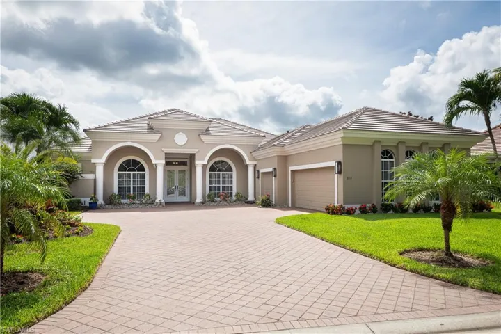 Mediterranean / spanish-style house featuring french doors, a garage, and a front lawn