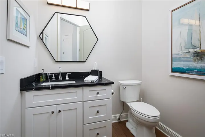 Bathroom with hardwood / wood-style floors, vanity, and toilet