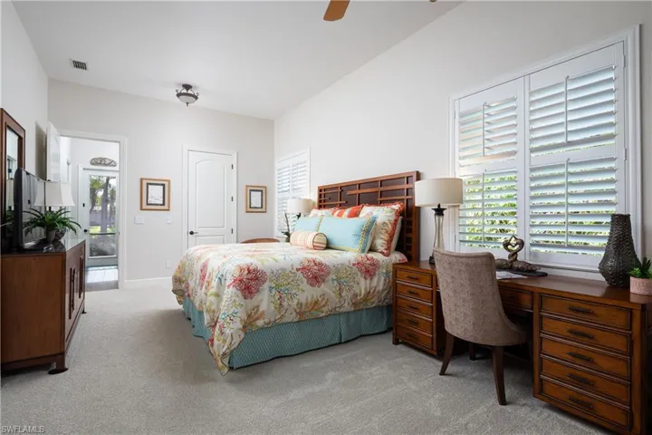 Carpeted bedroom featuring ceiling fan, access to exterior, and multiple windows