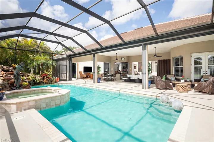 View of swimming pool featuring ceiling fan, an in ground hot tub, a patio area, outdoor lounge area, and a lanai