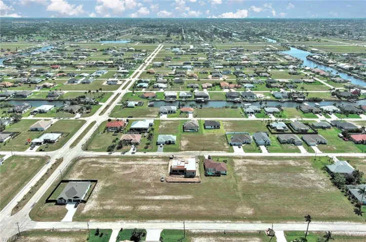Aerial view of property and surrounding area featuring a large body of water and nearby suburban area
