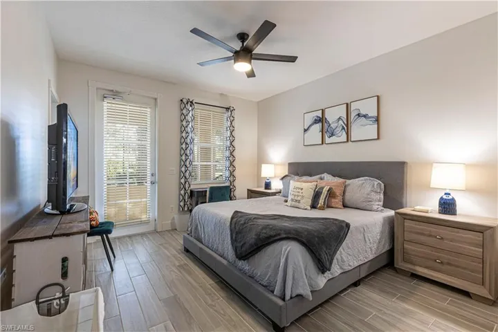 Bedroom featuring access to exterior, wood finish floors, and a ceiling fan