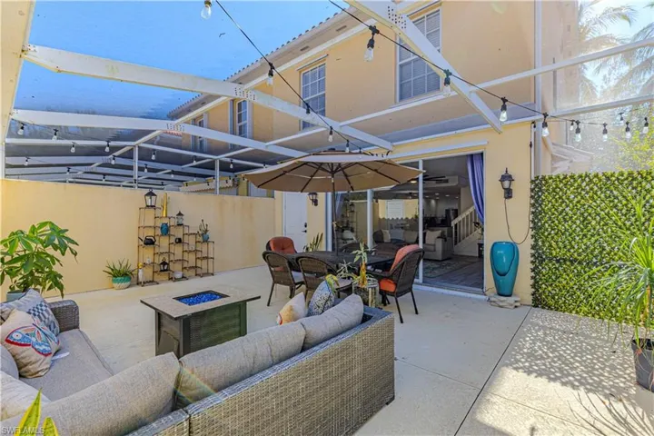 View of patio / terrace with a lanai, a sunroom, and an outdoor living space with a fire pit